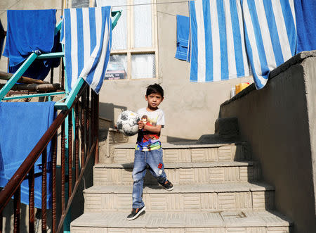 Murtaza Ahmadi, 7, an Afghan Lionel Messi fan, walks in front of his house in Kabul, Afghanistan December 8, 2018. REUTERS/Mohammad Ismail