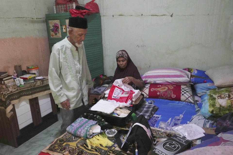 Husin bin Nisan and his wife Arnayu pack a suitcase before his departure for the hajj pilgrimage, at his house in Tangerang, Indonesia, Tuesday, June 6, 2023. (AP Photo/Achmad Ibrahim)
