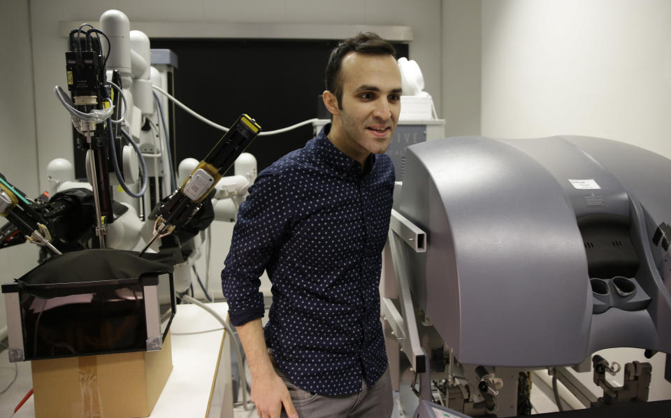 Iranian-born bioengineer researcher Nima Enayati stands as he works on a robotic surgery machine during an interview with the Associated Press at the Polytechnic University of Milan, Italy, Tuesday, Jan. 31, 2017. An Iranian researcher at Milan's Polytechnic University, Enayati was refused check-in Monday at Milan's Malpensa Airport for his U.S.-bound flight on Turkish Airlines after the Trump administration's executive order came down. (AP Photo/Luca Bruno)