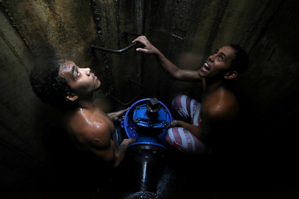 Locals collect water from an underground water main pipeline in Caracas, Venezuela, on March 12, 2019. (Photo: Ivan Alvarado/Reuters)