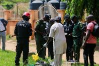 Security officers inspect items suspected to be explosives outside the medium-security prison in Kuje