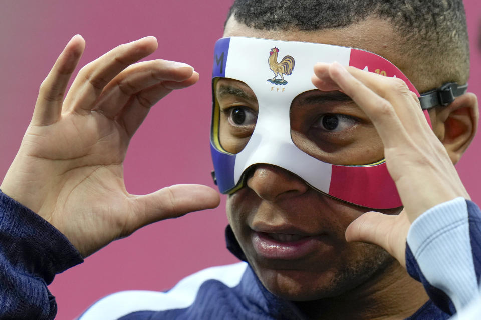 El francés Kylian Mbappe ajusta su máscara durante la sesión de entrenamiento de la selección en Leipzig, Alemania el jueves 20 de junio del 2024. (AP Foto/Hassan Ammar)