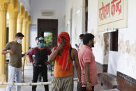 Prisoners, handcuffed to another, wait to give their nasal swab samples to test for COVID-19 in Prayagraj, India, Friday, Aug. 7, 2020. As India hit another grim milestone in the coronavirus pandemic on Friday, crossing 2 million cases and more than 41,000 deaths, community health volunteers went on strike complaining they were ill-equipped to respond to the wave of infection in rural areas. (AP Photo/Rajesh Kumar Singh)