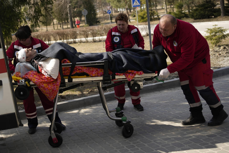 An injured man is wheeled on a stretcher at a local hospital in Novoiavorisk, western Ukraine, Sunday, March 13, 2022. Local officials in western Ukraine say a Russian airstrike has hit a military training base that has hosted NATO drills. (AP Photo/Bernat Armangue)