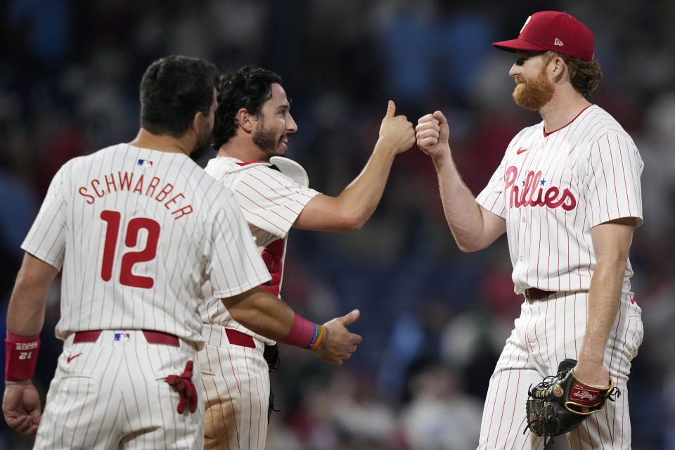 Philadelphia Phillies' Spencer Turnbull, from right, Garrett Stubbs and Kyle Schwarber celebrate after the Phillies won a baseball game against the Toronto Blue Jays, Tuesday, May 7, 2024, in Philadelphia. (AP Photo/Matt Slocum)