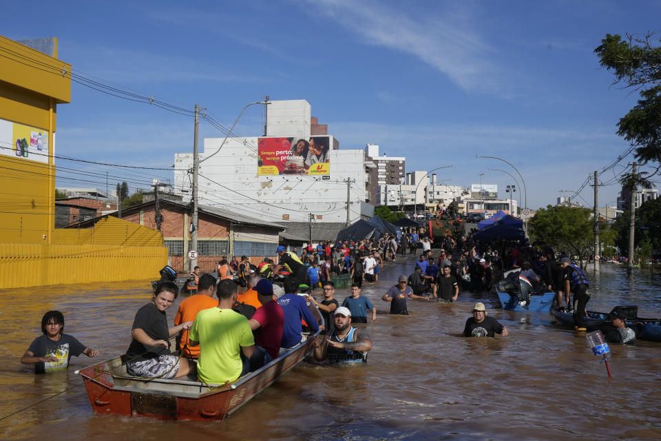 Volunteers gather in order to help residents evacuate from an area flooded by heavy rains, in Porto Alegre, Brazil, Tuesday, May 7, 2024. (AP Photo/Andre Penner)