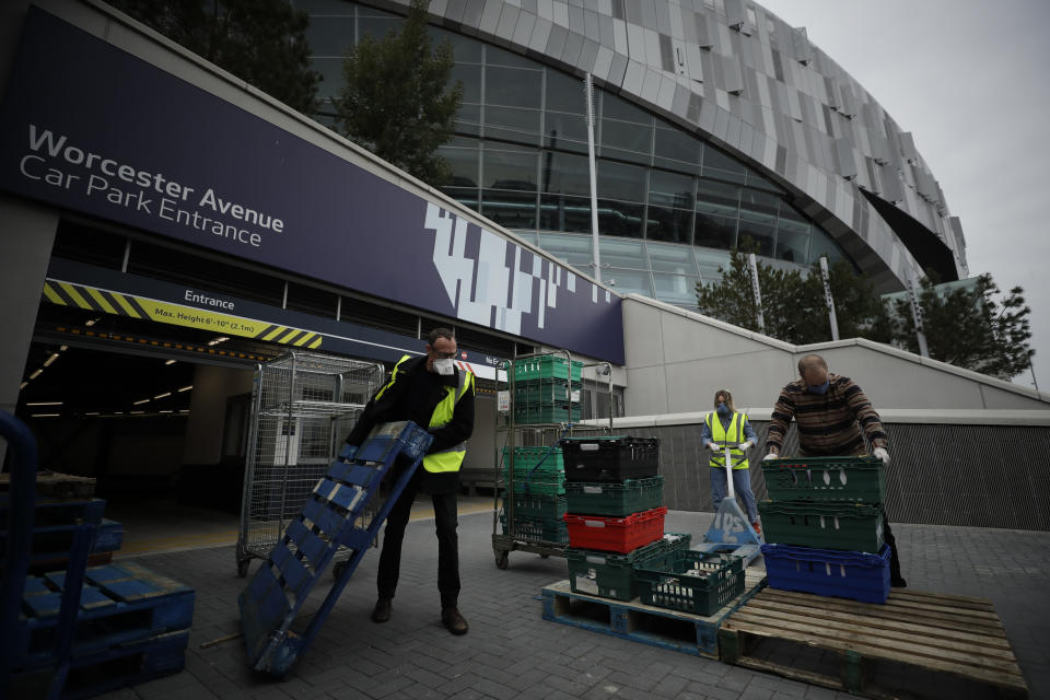 Volunteers for the Edible London food project sort donated food and essential items, to be delivered to vulnerable residents in the Harringey Council, at a hub setup as a result of Coronavirus inside the Tottenham Hotspur Stadium, in north London, Wednesday, April 1, 2020. The new coronavirus causes mild or moderate symptoms for most people, but for some, especially older adults and people with existing health problems, it can cause more severe illness or death.(AP Photo/Matt Dunham)