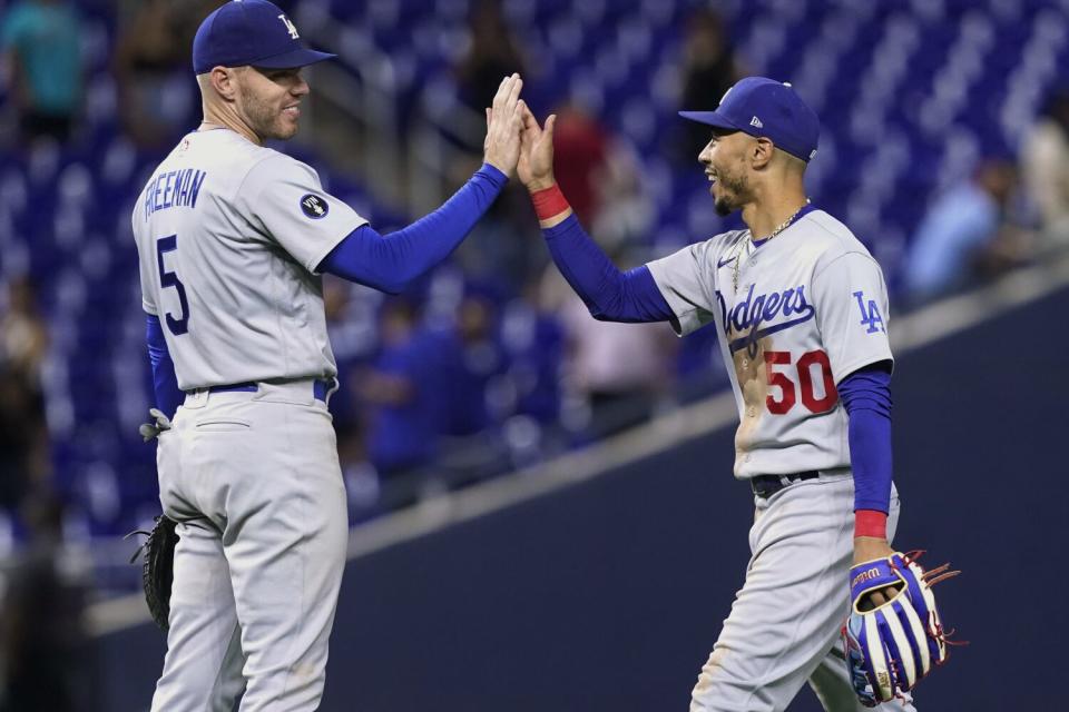 Dodgers' Mookie Betts, right, and Freddie Freeman celebrate the team's extra-inning win at Miami.