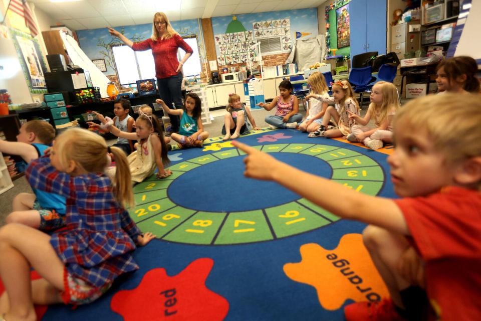 Students in a combined TK and kindergarten class at Alturas Elementary School point along with their teacher.