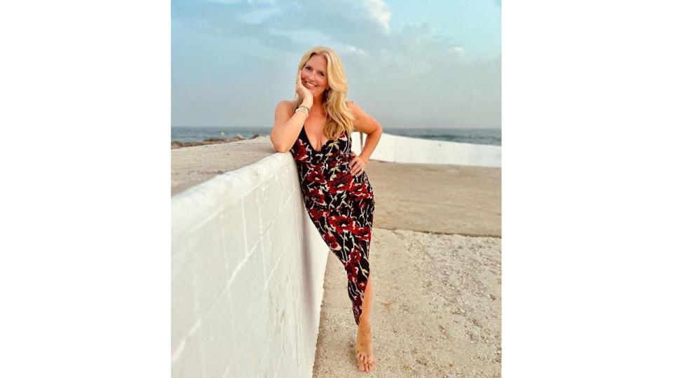 Rod Stewart wife Penny Lancaster wearing black and red floral dress with plunging neckline at seaside