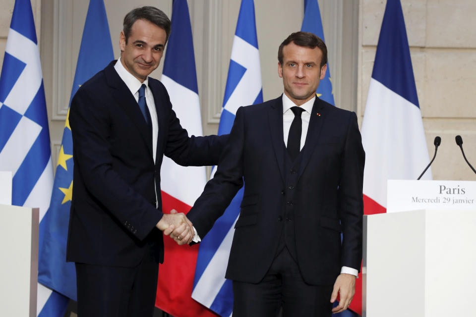 French President Emmanuel Macron, right, and Greek Prime Minister Kyriakos Mitsotakis shake hands during a joint press conference at the Elysee Palace in Paris, Wednesday Jan. 29, 2020. (Benoit Tessier/Pool via AP)