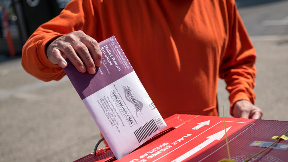 A resident drops a ballot inside a ballot box at an early voting polling location for the 2020 Presidential election in San Francisco, California, U.S., on Tuesday, Oct. 6, 2020. (David Paul Morris/Bloomberg via Getty Images)