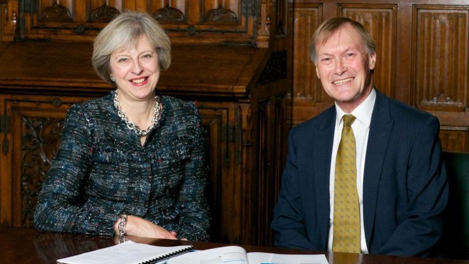 Amess junto a la ex primera ministra británica Theresa May.