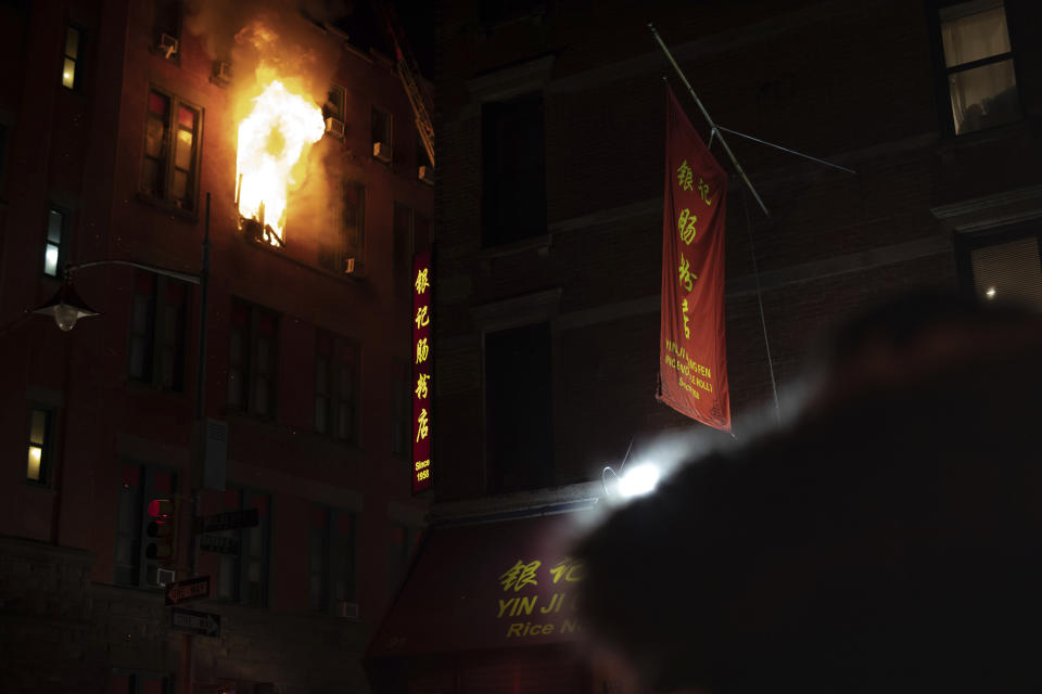 Fire blows out of a window in the Chinatown section of New York, Thursday, Jan. 23, 2020. New York City firefighters battled a raging blaze at a building in the city's Chinatown area Thursday night, Firefighters said they were called about 8:45 p.m. to 70 Mulberry Street for a fire on the fourth and fifth floors of the building, NYFD officials said. (AP Photo/Robert Bumsted)