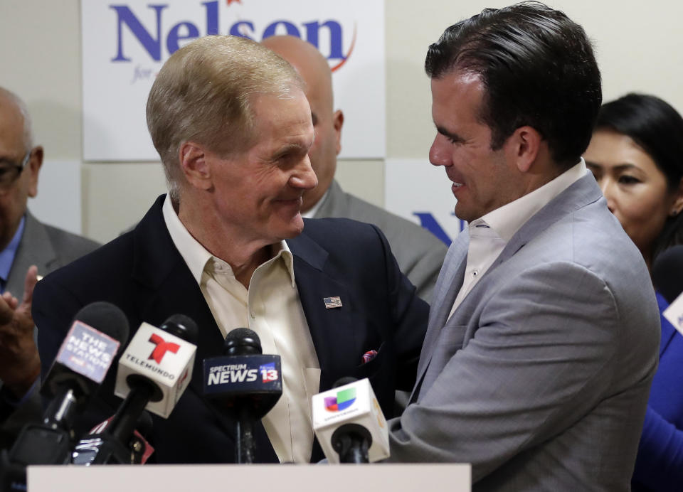 U.S. Sen. Bill Nelson, left, is embraced after Puerto Rico Governor Ricardo Rossello, right, endorsed his bid for the senate in front of supporters and media during a news conference Monday Oct. 1, 2018, in Orlando, Fla. (AP Photo/John Raoux)