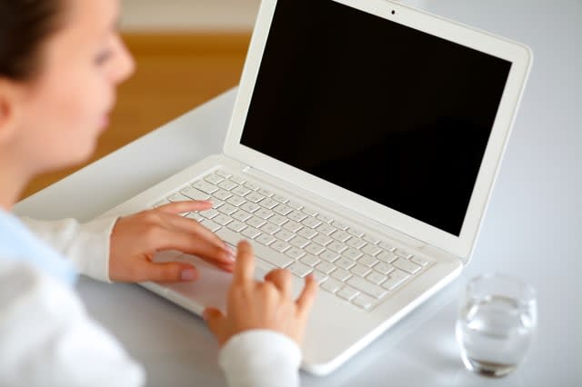 Pretty young woman browsing the internet on her laptop at home