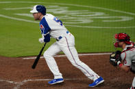Atlanta Braves first baseman Freddie Freeman (5) drives in a run with a ground ball as Philadelphia Phillies catcher J.T. Realmuto (10) looks on in the seventh inning of a baseball game Saturday, April 10, 2021, in Atlanta. (AP Photo/John Bazemore)