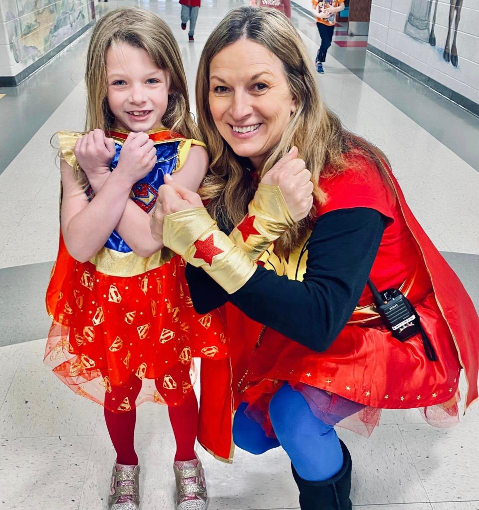 Little Natalie Wilkinson is all smiles in her superhero costume with Principal Lynn Jacomen at the finale of Kindness Week.