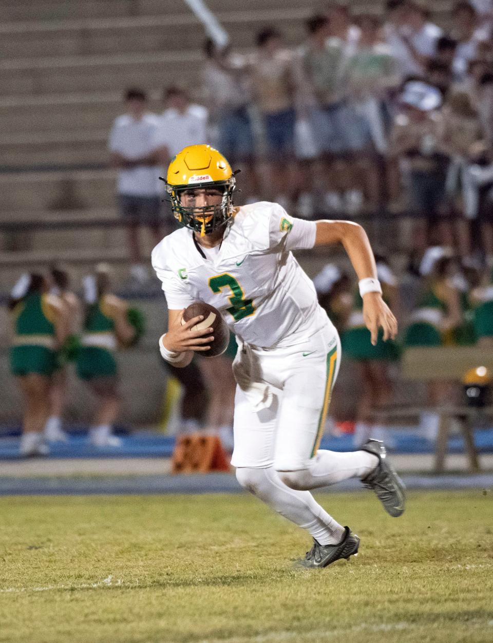 Catholic quarterback Ryan Huff (No. 3) scrambles out of the pocket on runs for the near sideline during Friday night's game against Gulf Breeze.