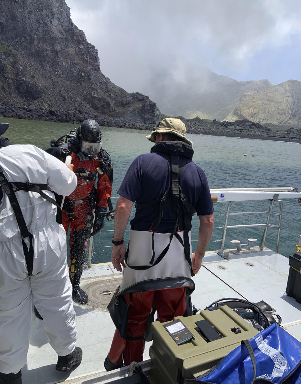 Police divers prepare to search the waters near White Island off the coast of Whakatane, New Zealand, Saturday Dec.14, 2019. A team of nine from the Police National Dive Squad resumed their search early Saturday for a body seen in the water following Monday's volcanic eruption. (New Zealand Police via AP)