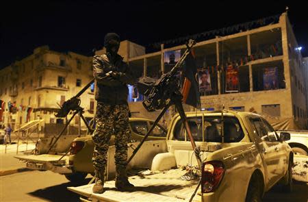 A member of a heavily armed militia group stands near his weapon in Freedom Square in Benghazi 18, 2014. REUTERS/Esam Omran Al-Fetori