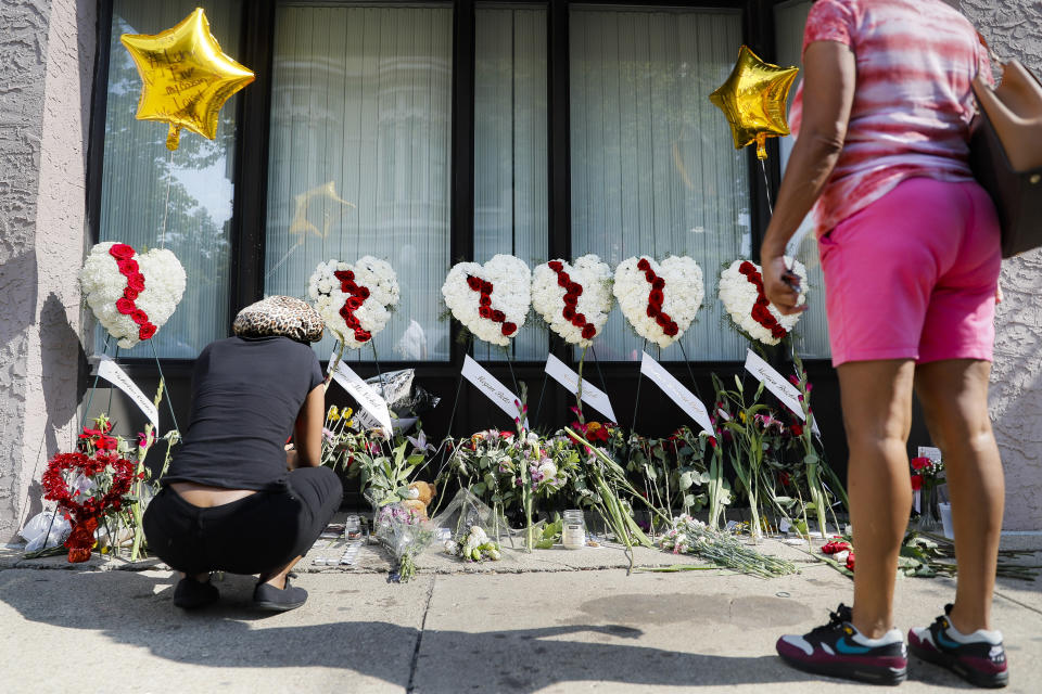 Mourners pause at a makeshift memorial Tuesday, Aug. 6, 2019, for the slain and injured in the Oregon District after a mass shooting that occurred early Sunday morning, in Dayton. (AP Photo/John Minchillo)