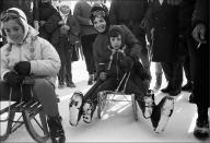 <p>Jackie Kennedy sits with son John Jr. on a sled later in the day at their ski party. Daughter Caroline sits on another sled in front.</p>