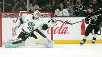 Seattle Kraken goaltender Chris Driedger, left, makes a glove save as Los Angeles Kings left wing Viktor Arvidsson watches during the third period of an NHL hockey game Monday, March 28, 2022, in Los Angeles. (AP Photo/Mark J. Terrill)