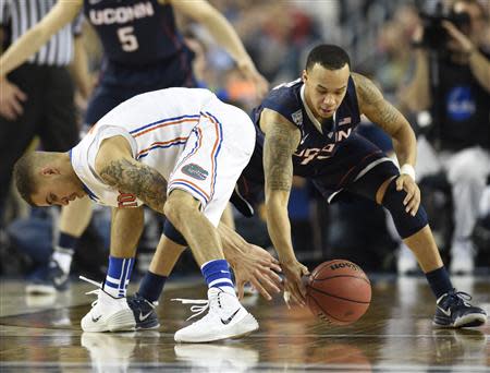 Apr 5, 2014; Arlington, TX, USA; Connecticut Huskies guard Shabazz Napier (13) and Florida Gators guard Scottie Wilbekin (5) battle for a loose ball in the second half during the semifinals of the Final Four in the 2014 NCAA Mens Division I Championship tournament at AT&T Stadium. Mandatory Credit: Bob Donnan-USA TODAY Sports