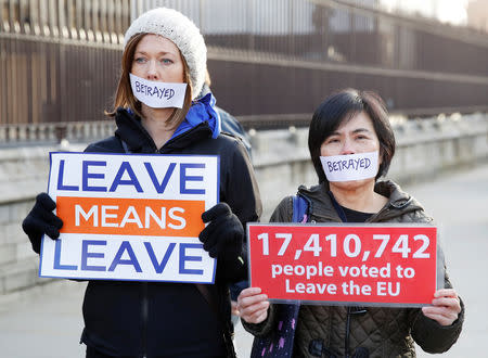 Pro-Brexit demonstrators wear tape accross their mouths and hold placards outside the Houses of Parliament in London, Britain, december 11, 2018. REUTERS/Phil Noble