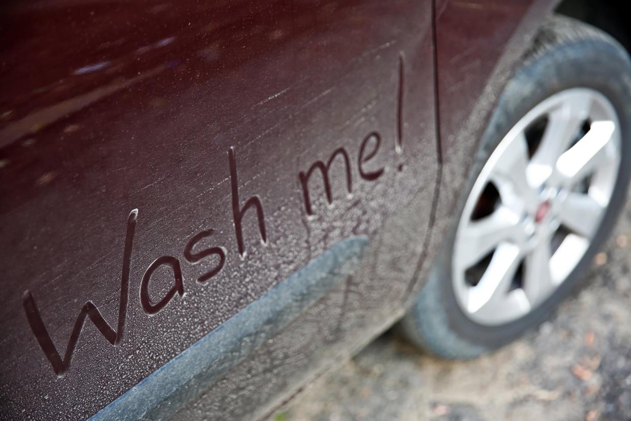 written text WASH ME on dirty car