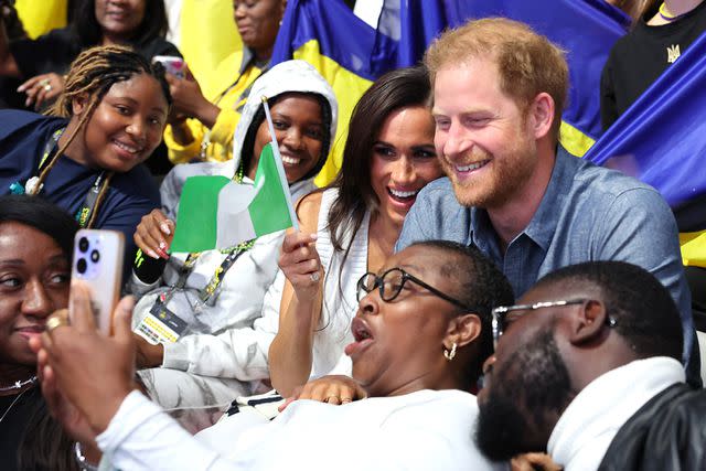 <p>Chris Jackson/Getty</p> Meghan Markle and Prince Harry take selfies with fans as they attend a Ukraine-Nigeria event at the Invictus Games on Sept. 14, 2023 in Duesseldorf, Germany.