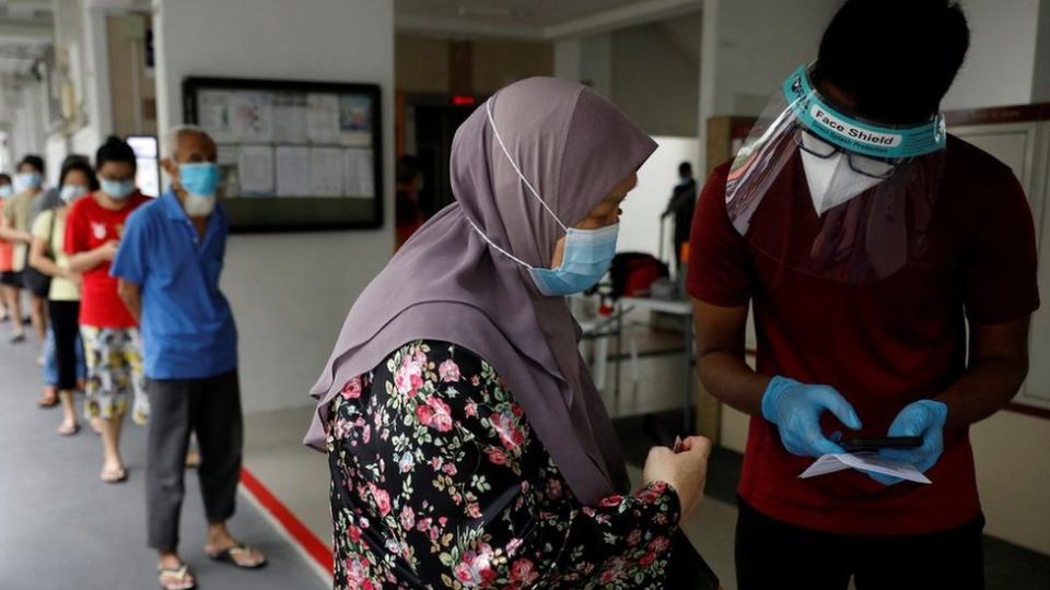 Los residentes de una urbanización pública hacen cola para las pruebas obligatorias de coronavirus en Singapur el 21 de mayo de 2021