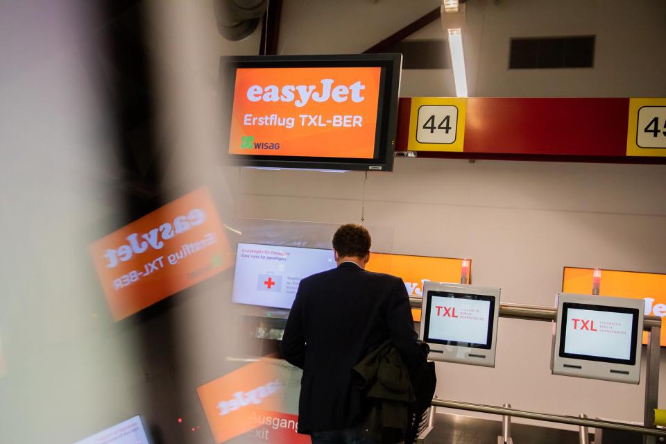 Maiden flight TXL-BER" is on the screen of a check-in counter at Berlin-Tegel Airport