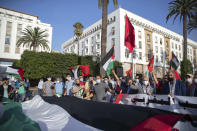 People hold a large Palestinian flag during a protest against normalizing relations with Israel, in Rabat, Morocco, Friday, Sept. 18, 2020. Despite a government ban on large gatherings aimed at preventing the spread of the coronavirus, scores of Moroccans staged a protest outside parliament building in the capital Rabat on Friday to denounce Arab normalization agreements with Israel. (AP Photo/Mosa'ab Elshamy)