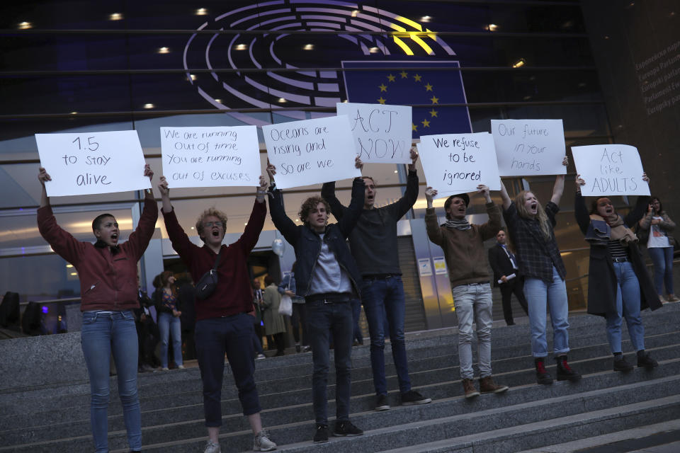 Climate activists hold up placards outside the European Parliament in Brussels, Sunday, May 26, 2019. From Germany and France to Cyprus and Estonia, voters from 21 nations went to the polls Sunday in the final day of a crucial European Parliament election that could see major gains by the far-right, nationalist and populist movements that are on the rise across much of the continent. (AP Photo/Francisco Seco)