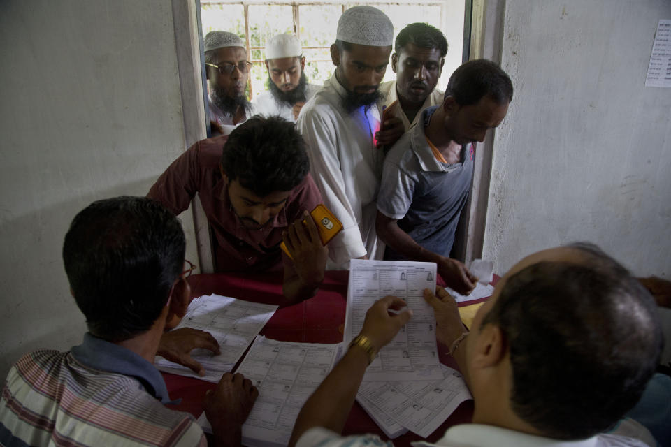 In this Saturday, Aug. 31, 2019, file photo, villagers check for their names in the final list of the National Register of Citizens (NRC) at an NRC center in Buraburi village in Morigaon district, in the northeastern Indian state of Assam. India has been embroiled in protests since December, when Parliament passed a bill amending the country's citizenship law. (AP Photo/Anupam Nath, File)