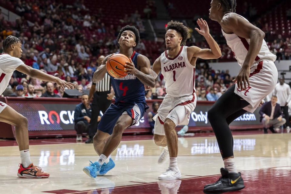 South Alabama guard Marcus Millender (4) gets past Alabama guard Mark Sears (1) for a shot during the second half of an NCAA college basketball game, Tuesday, Nov. 14, 2023, in Tuscaloosa, Ala. (AP Photo/Vasha Hunt)