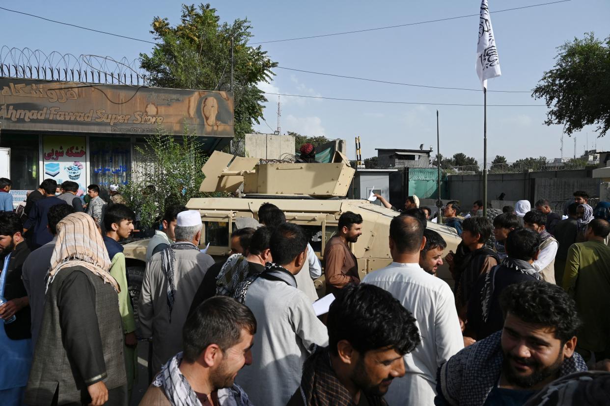 Afghan people wanting to leave the country queue up in front of the British and Canadian embassy in Kabul on August 19, 2021 after Taliban's military takeover of Afghanistan.   / AFP / WAKIL KOHSAR