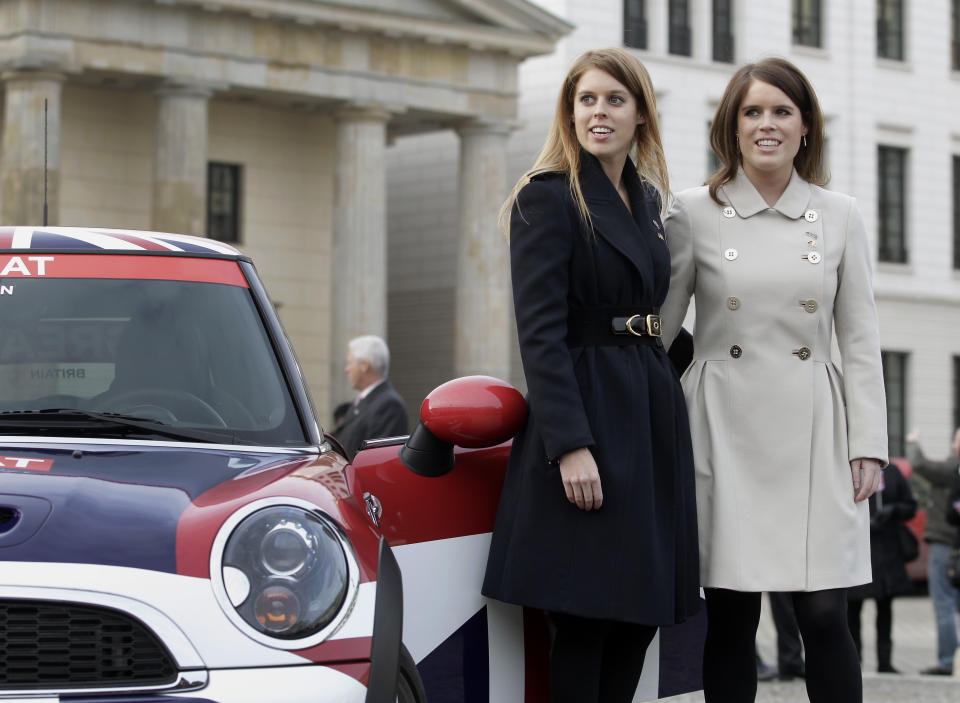 The members of the British royal family, Princess Beatrice of York, left, and Princess Eugenie of York, right, pose for the media during a promotion event for the Great Britain MINI Tour 2013 at the Brandenburg Gate in Berlin, Germany, Thursday, Jan. 17, 2013. It was meant to be a Mini adventure that nearly became a major embarrassment. Two British royals on a mission to promote their country broke German road rules by running a red light near Berlin's iconic Brandenburg Gate. With photographers and police in tow, Princess Eugenie and her older sister Princess Beatrice then took a swift right into the safety of the British embassy compound. At least the 22 and 24-year-old sisters didn't have to decide which side of the road to drive on. The entire 500-meter (550-yard) staged tour was along one-way streets (AP Photo/Michael Sohn)