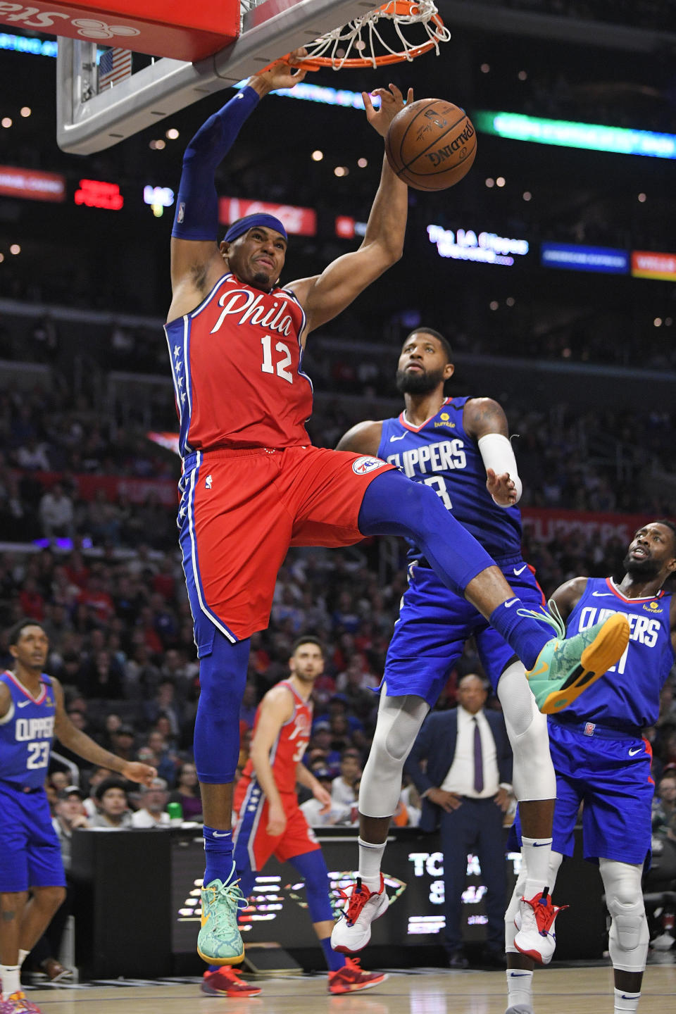Philadelphia 76ers forward Tobias Harris, left, dunks as Los Angeles Clippers guard Paul George defends during the second half of an NBA basketball game Sunday, March 1, 2020, in Los Angeles. The Clippers won 136-130. (AP Photo/Mark J. Terrill)