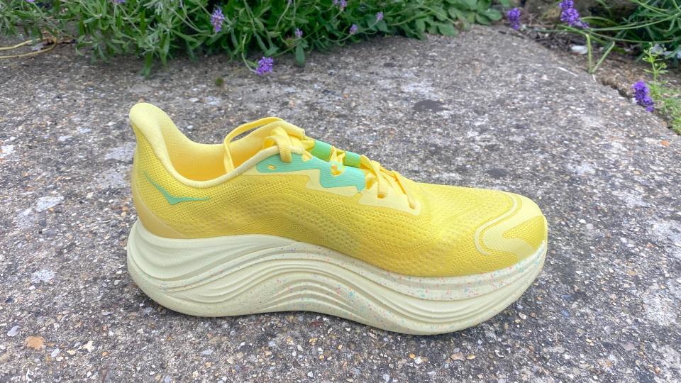 The Hoka Skyward X in yellow on a sidewalk