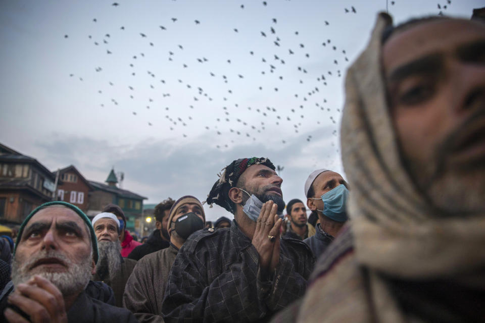 Kashmiri Muslim devotees pray as a head priest displays a relic of Sufi saint Syed Abdul Qadir Gilani at his shrine in Srinagar, Indian controlled Kashmir, Friday, Nov. 27, 2020. Hundreds of devotees thronged to the shrine Friday to mark the saint's Urs or yearly commemoration. (AP Photo/Dar Yasin)