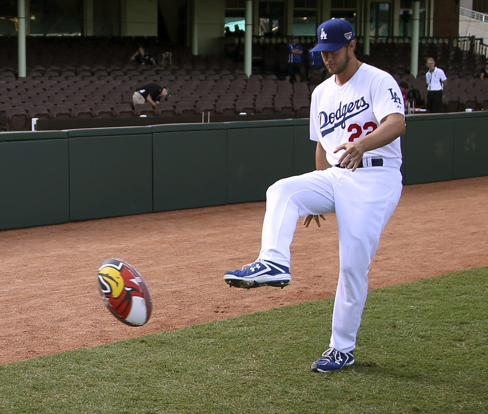 The Los Angeles Dodgers' Clayton Kershaw kicks a rugby league ball at the Sydney Cricket Ground in Sydney, Wednesday, March 19, 2014. The MLB season-opening two-game series between the Dodgers and Diamondbacks in Sydney will be played this weekend. (AP Photo/Rick Rycroft)