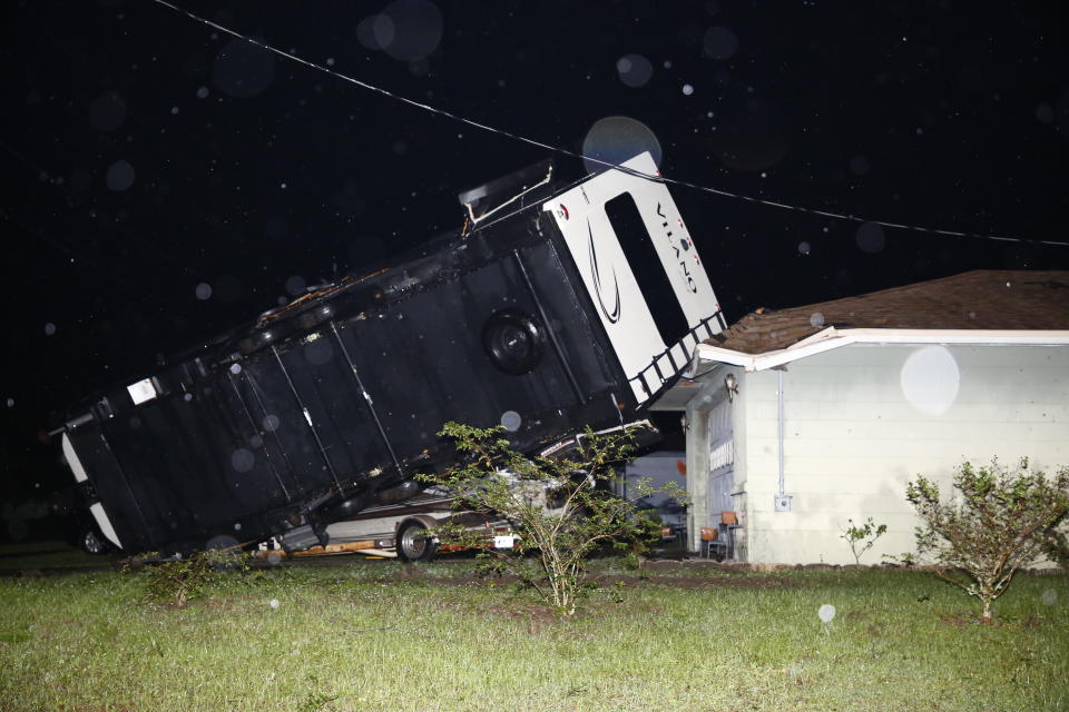 A camper rests on top of a boat trailer and the corner of a home as Tropical Storm Nestor passed the area on Saturday, Oct. 19, 2019 in Kathleen, Fla. Nestor was downgraded Saturday after it spawned a tornado that damaged several homes. (Luis Santana/Tampa Bay Times via AP)