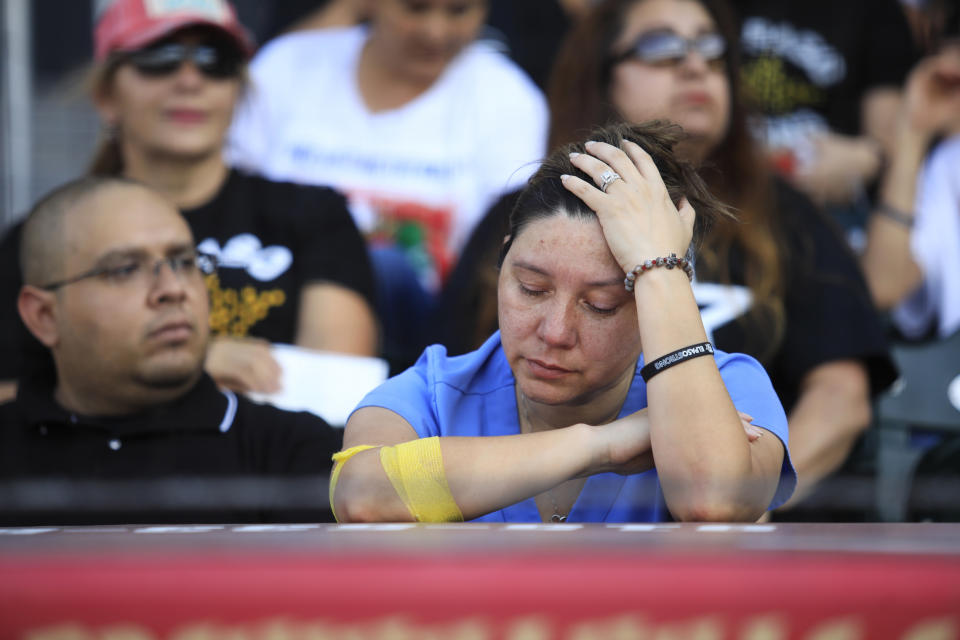 Lulu Cordero mourns as memorial videos are shown of the victims of the Aug. 3 mass shooting during a memorial service, Wednesday, Aug. 14, 2019, at Southwest University Park, in El Paso, Texas. (AP Photo/Jorge Salgado)