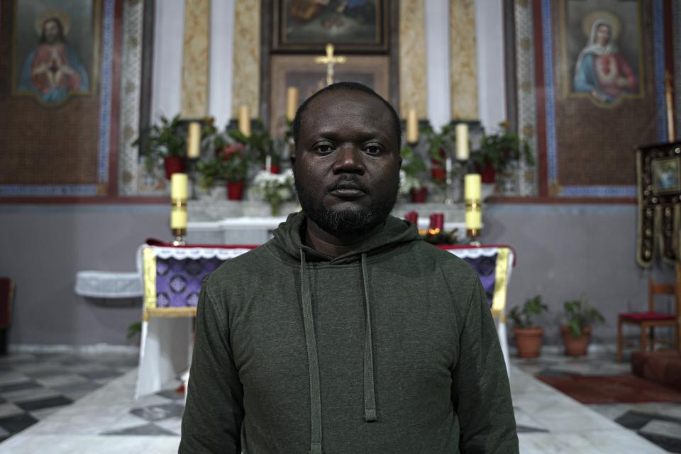 Christian Tango Muyaka, a 30-year-old asylum-seeker from Congo, poses for a photograph inside a Catholic church in Mytilene port, on the northeastern Aegean island of Lesbos, Greece, Monday, Nov. 29, 2021. Muyaka will attend a Sunday service held by the pope at a new migrant camp on Lesbos. Pope Francis is heading back to the Greek island of Lesbos to meet migrants and asylum seekers for the second time in five years. (AP Photo/Panagiotis Balaskas)