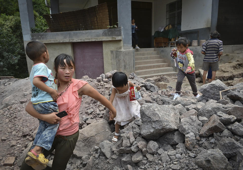 A woman brings the children evacuate from an earthquake hit Luozehe town in Yiliang county in southwest China's Yunnan province Saturday, Sept. 8, 2012. Authorities poured aid into a remote mountainous area of southwestern China and rescue workers with sniffer dogs searched for survivors Saturday after twin earthquakes killed at least 80 people. (AP Photo) CHINA OUT