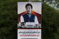 A poster with images of Imran Khan is displayed in the celebration of his government at a highway in Islamabad, Pakistan, Saturday, Aug. 18, 2018. Pakistan's cricket star-turned-politician Khan was sworn in as prime minister on Saturday despite protests by opposition parties, which accuse the security services of intervening on his behalf in last month's elections. The poster reads 'Welcome to this new government with new hopes and aspiration'. (AP Photo/Anjum Naveed)