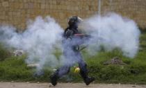 A police officer fires tear gas at anti-government protesters during clashes in Gachancipa, Colombia, Friday, May 7, 2021. The protests that began last week over a tax reform proposal continue despite President Ivan Duque's withdrawal of the tax plan on Sunday, May 2. (AP Photo/Ivan Valencia)